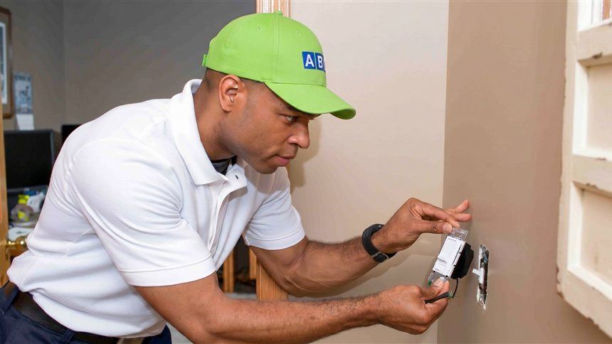 ABC electrician repairing a wall outlet