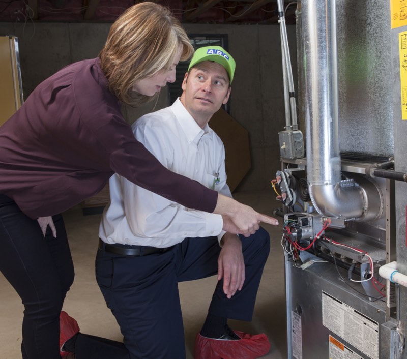 ABC technician walking a homeowner through her furnace