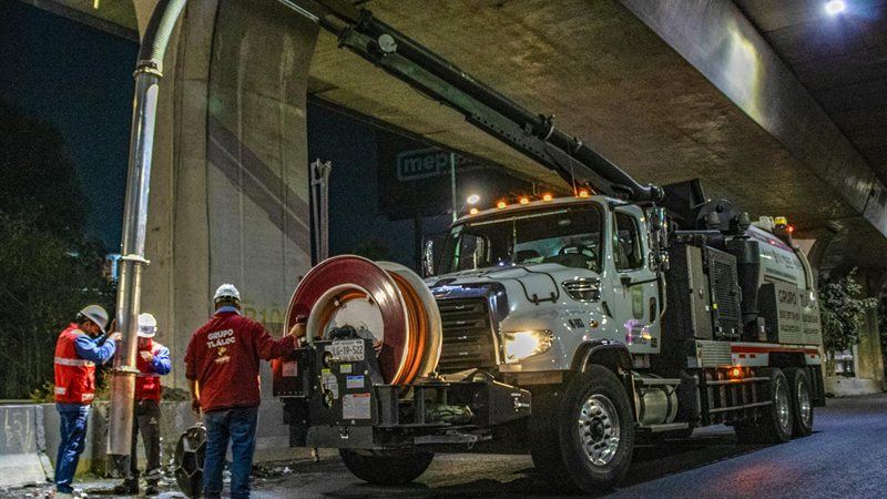 Sewer crew clearing a main line with a vacuum truck
